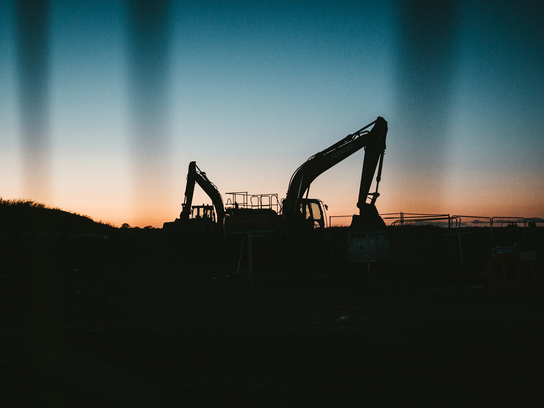 Excavators silhouetted on a construction site at dusk