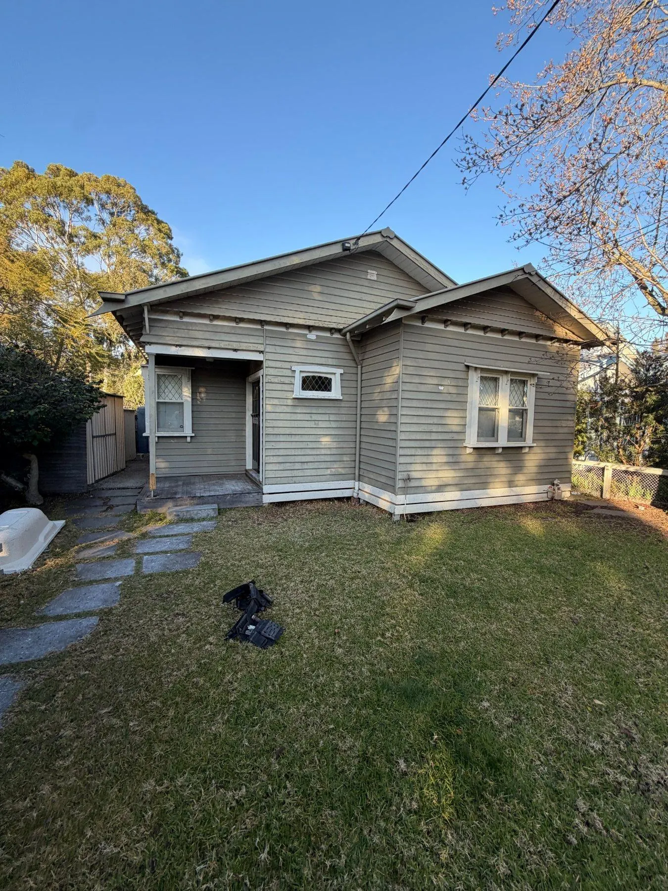 Northcote weatherboard home before replacement, faded grey boards and tired windows