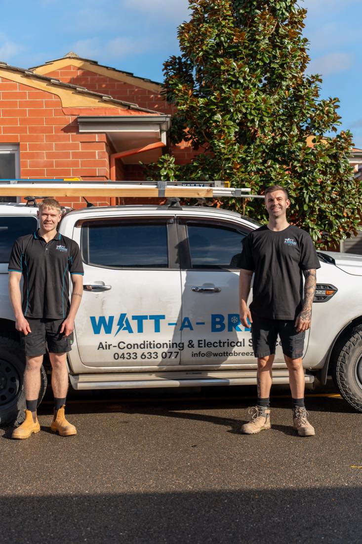 Two Watt A Breeze technicians standing in front of the company vehicle