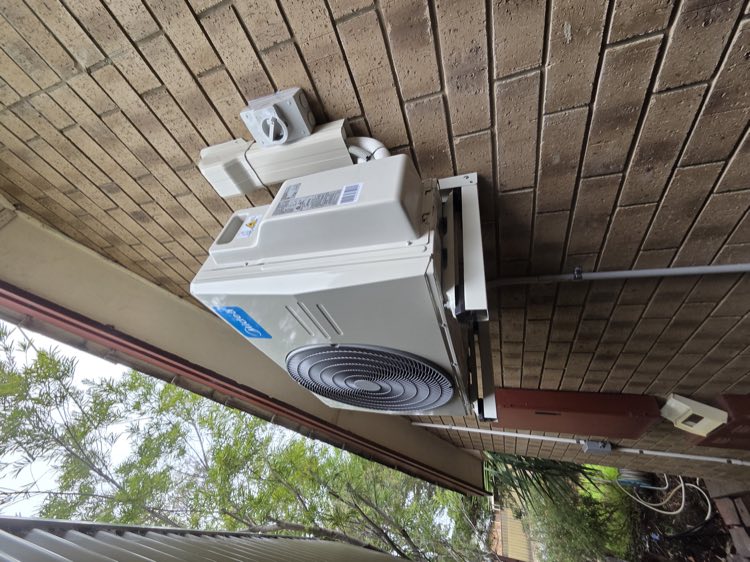 Air conditioning outdoor unit mounted on brick veneer