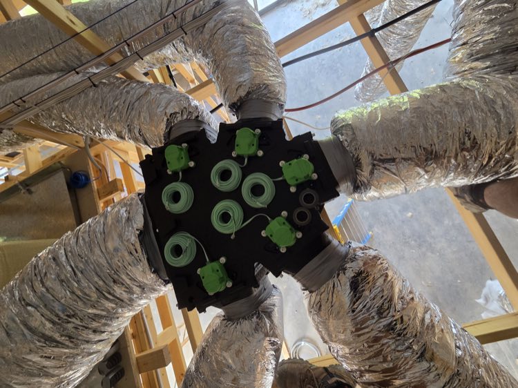 Ducted zone control manifold being wired during a ceiling void install