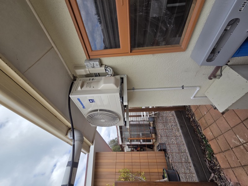 Panasonic outdoor unit installed under an eave